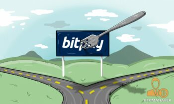 A road splitting at a bitpay sign. It has a fork in it implying that bitpay is separating ways.