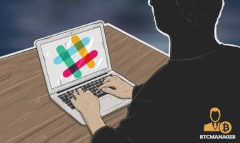 A shadowy figure types on a laptop with the Slack company logo emblazoned across the screen, scammers have been increasingly infilitrating Slack channels of blockchain startups and projects
