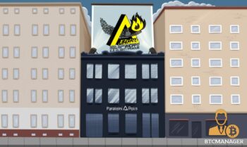 The blacked out three storey building of Paralelni Polis in Prague is shown, contrasting from the buildings beside it, a yellow impossible triangle with a flame bursting through it and the slogan Liberate! is shown on top of the building for Hacker's Congress '17