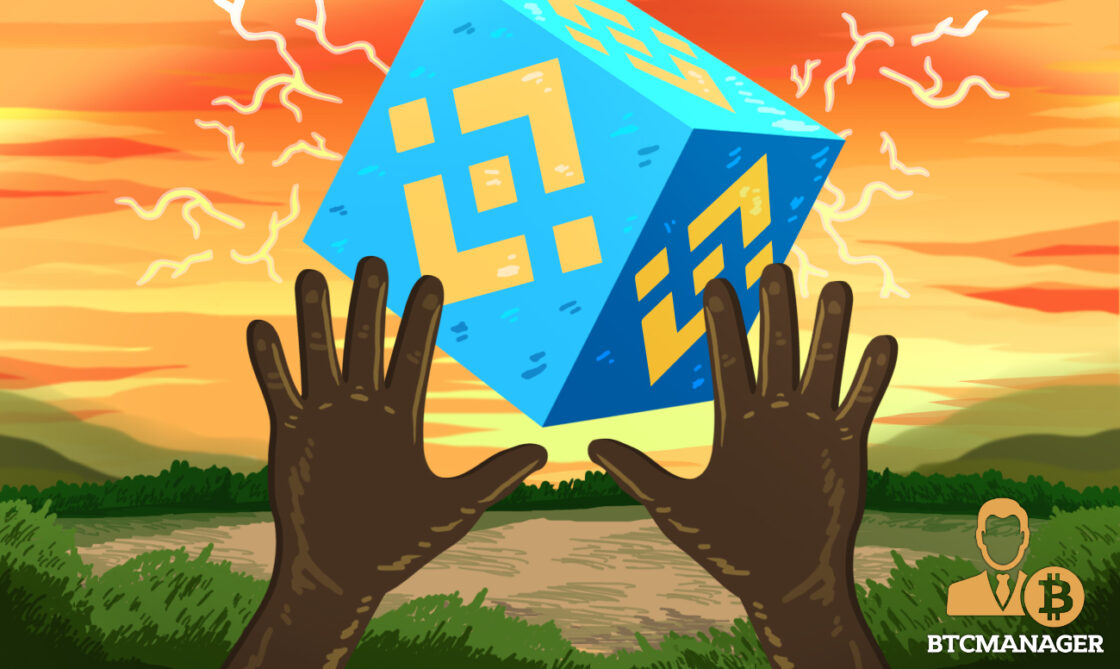 Hands Reaching for a Binance-Branded Blue Block
